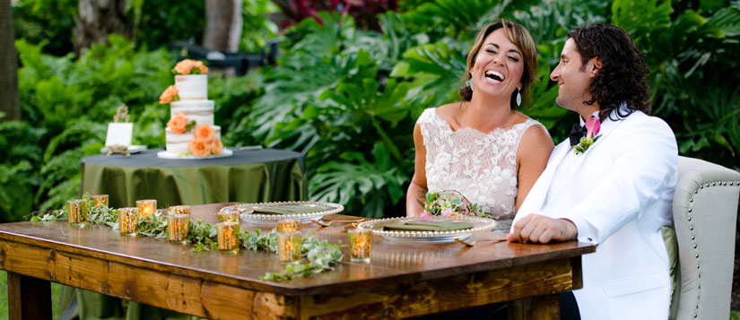 Two happy newlyweds sitting at the bride and groom's table at the Truman Little White House, Key West, FL